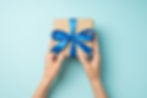 Gift box with bow and hands holding it