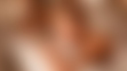 A smiling couple lying on massage tables, about to enjoy a side-by-side massage