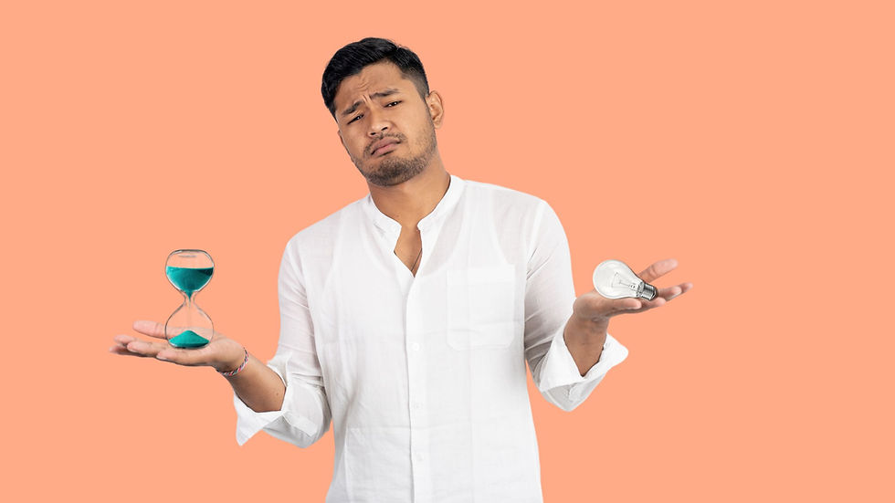 Asian man in 30's frowns at camera while holding an hourglass and a light bulb for time and energy balance