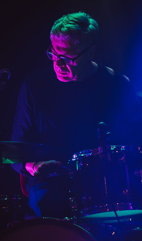 image of man drumming with red glow and dark backround