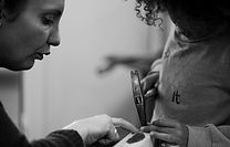 Aurore Mazères dans son atelier, concentrée sur un projet de restauration de siège, représentant son expertise et sa passion pour la tapisserie.