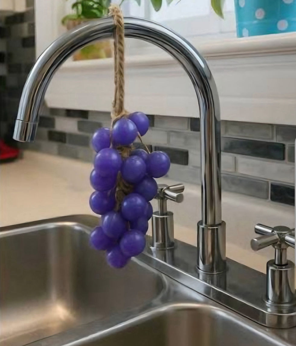 Purple grape cluster soap hanging from a kitchen faucet