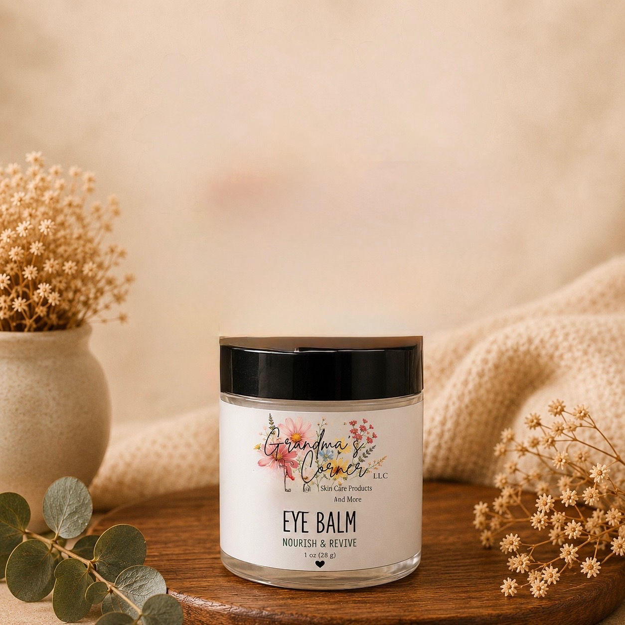 Jar of Eye Balm on a wooden surface with flowers.
