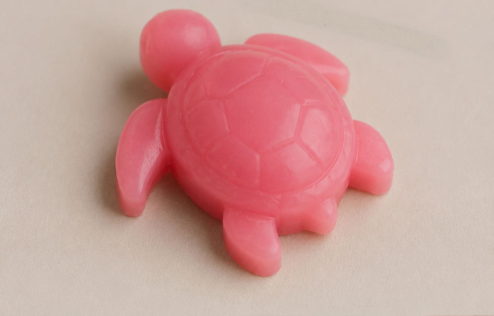 Small pink resin mini turtle charm on a neutral background