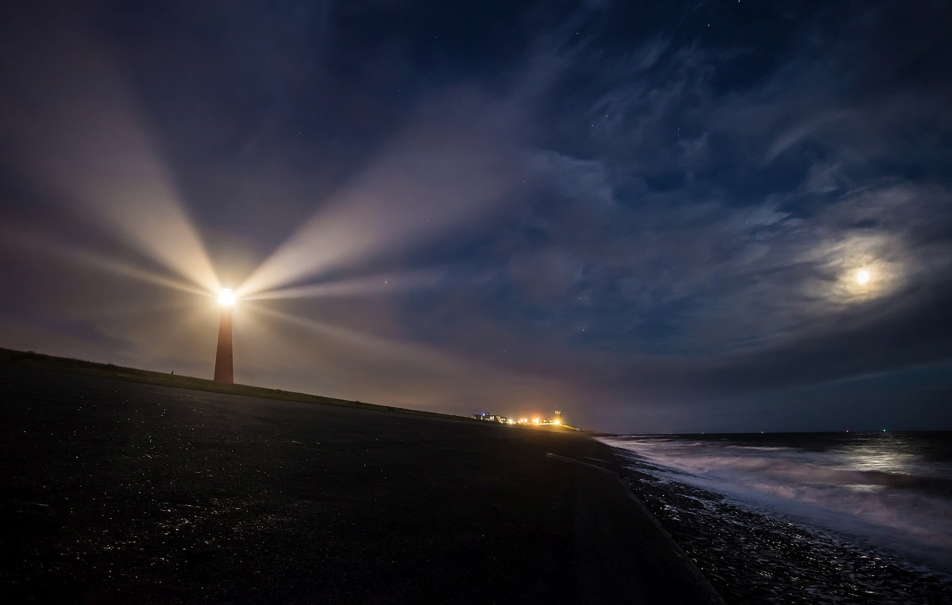 a lighthouse lighting up a dark sky