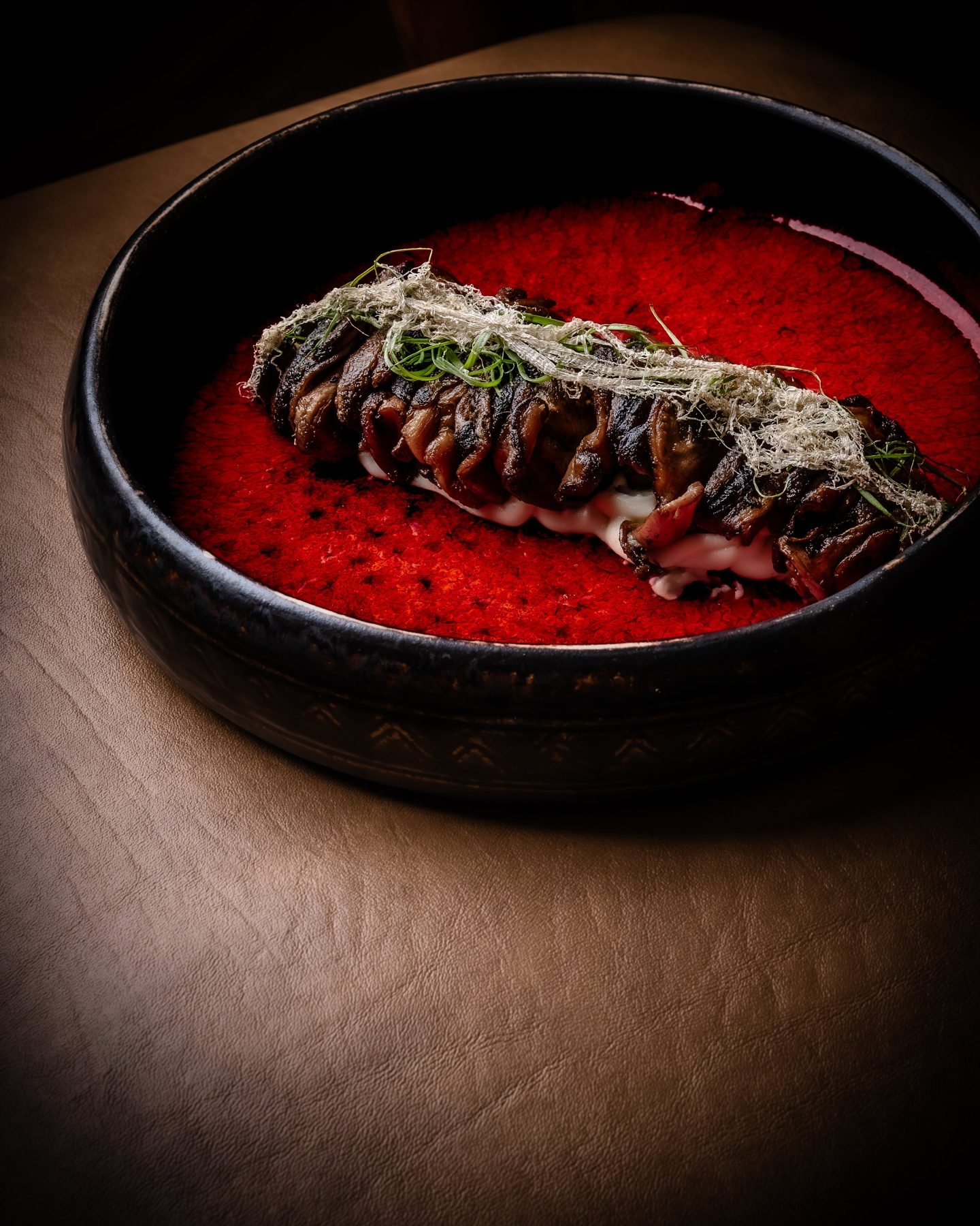 Glazed mushrooms in a bowl of vivid red sauce