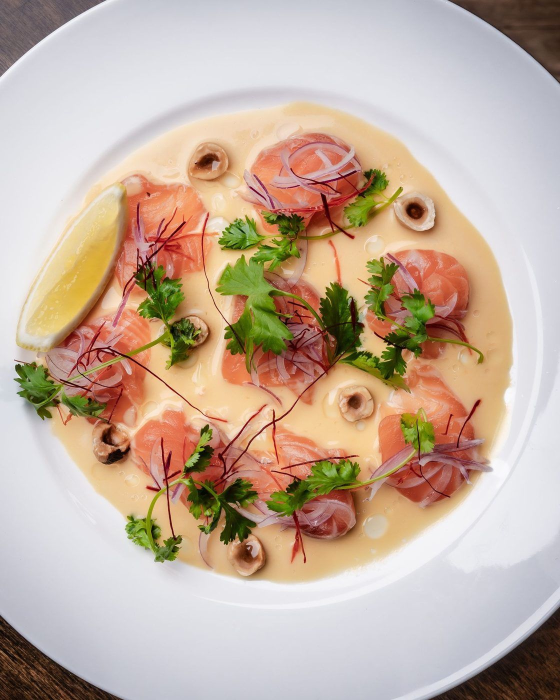 Citrus-cured fish on a white plate