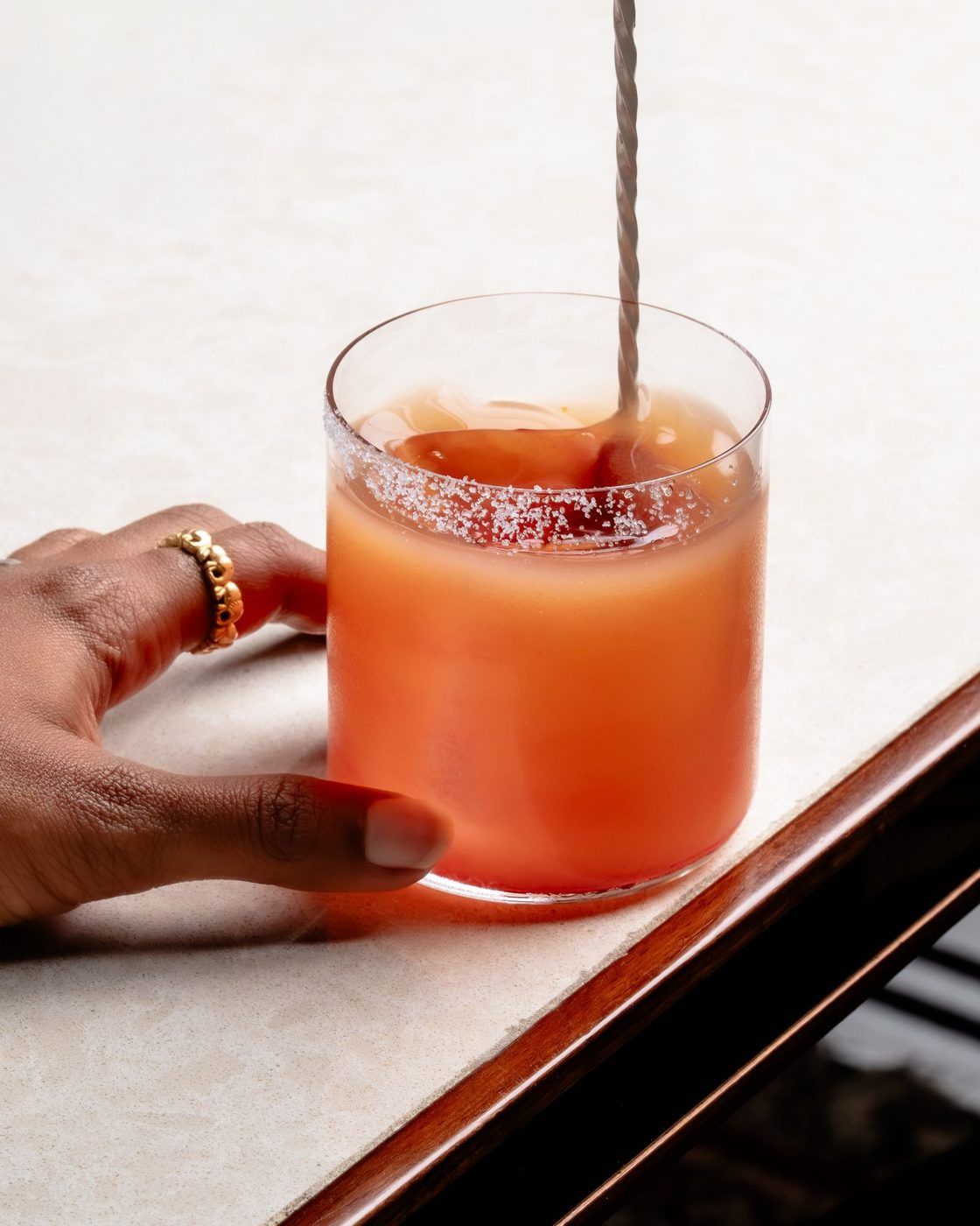 Hand holding a tequila sunrise