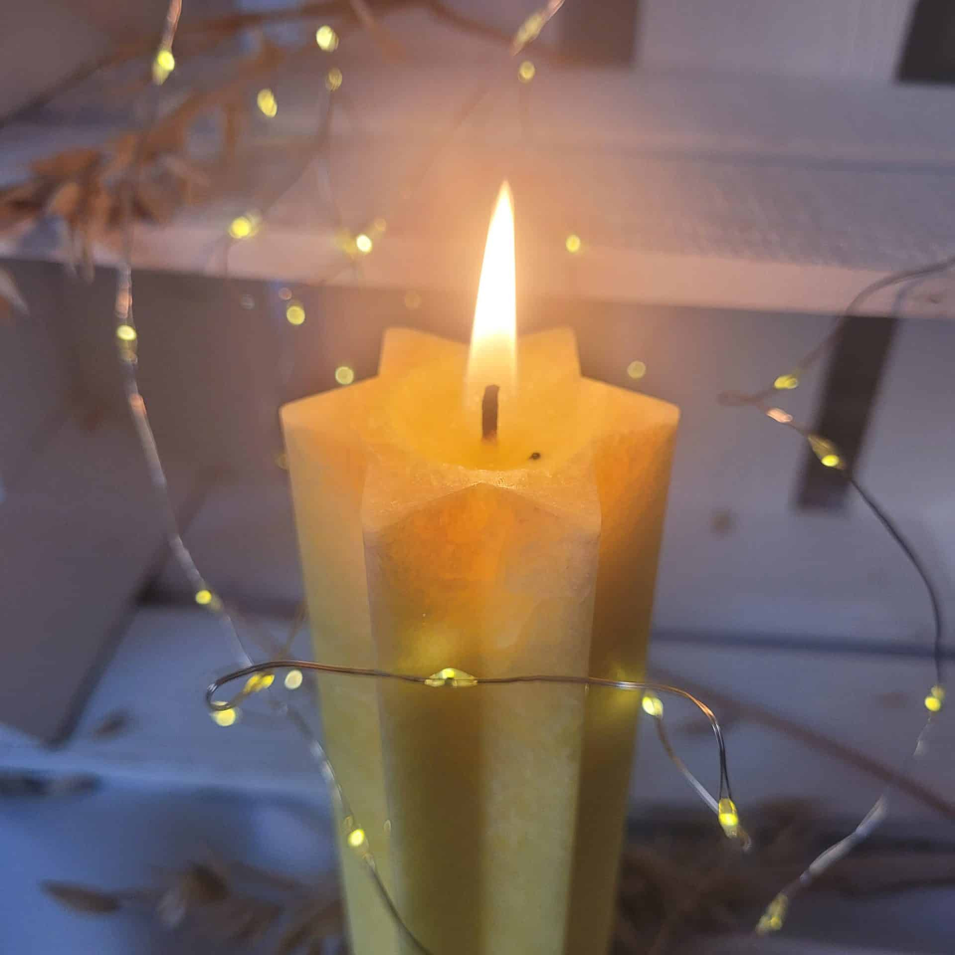 Brennende gelbe Kochaw Schabbatkerze in Davidsternform mit hellem, stimmungsvollem Licht
