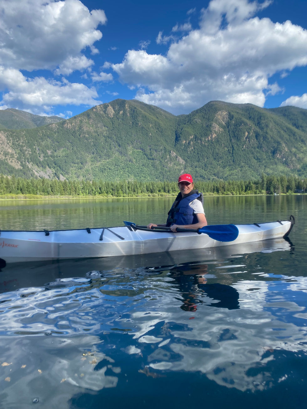 Cathy in the Oru Kayak on Lake Savage with mountains in the background!