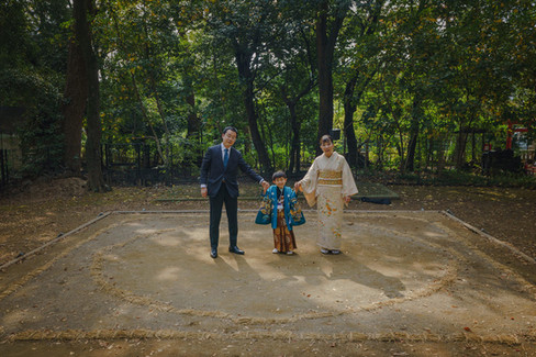 世田谷八幡宮の土俵を背景に立つ七五三の家族。伝統ある相撲ゆかりの場所で残す特別な記念写真