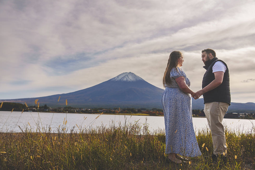 Couple holding hands with Mt. Fuji behind them at Lake Kawaguchiko, moments after a surprise proposal in Japan