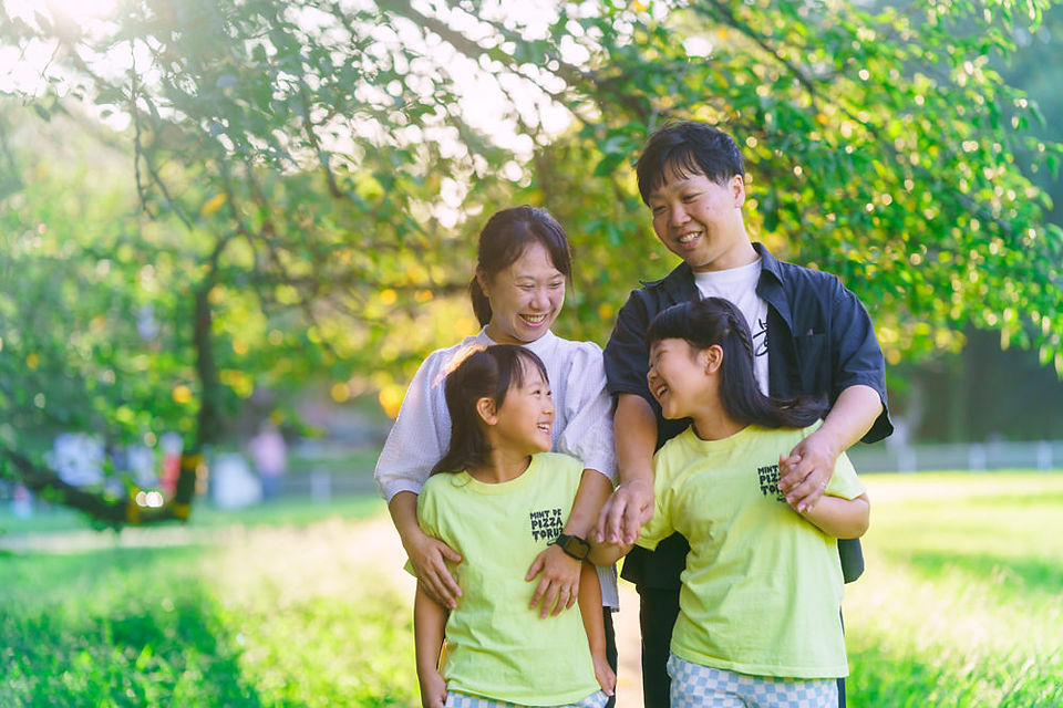 Parents sharing a joyful moment with their daughters in a natural family photography session