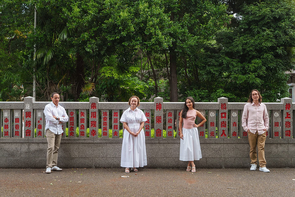Family portrait beside a stone wall with Japanese inscriptions near Zojoji Temple