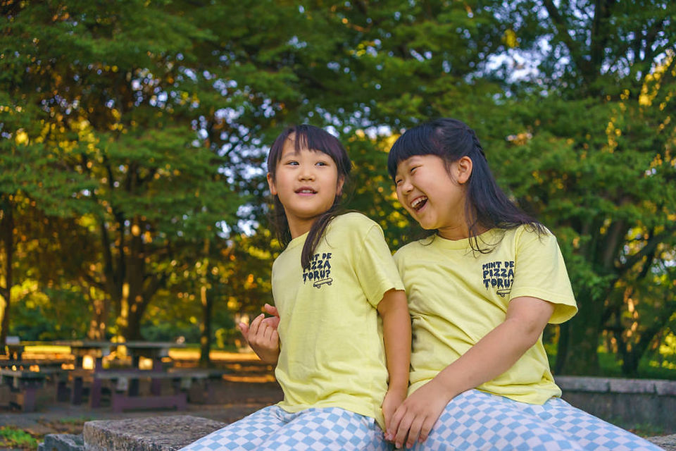 夏休みの砧公園で笑顔を見せる姉妹の自然なポートレート