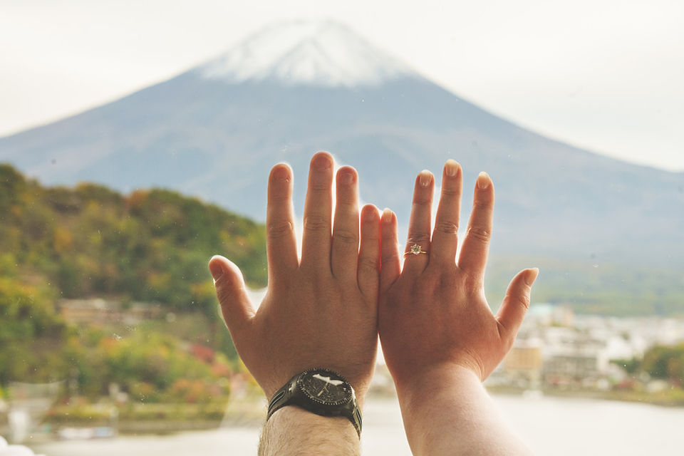 Close-up of hands with an engagement ring against Mt. Fuji, photographed at Via Mizuno Hotel in Lake Kawaguchiko, Japan