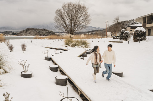 Snowy Lake Kawaguchiko couple walking on wooden path winter Japan proposal photoshoot