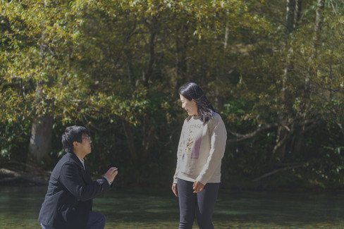 A close-up moment of a proposal in Kamikochi, Japan, captured in a quiet natural setting