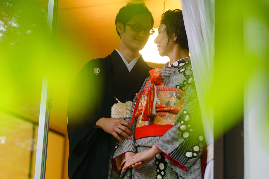 窓辺で見つめ合う和装の新郎新婦、軽井沢の別荘にて撮影