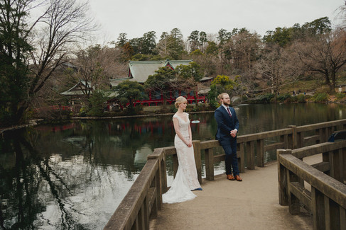 Bride and groom standing on a bridge with the lake and shrine scenery at Inokashira Park Tokyo