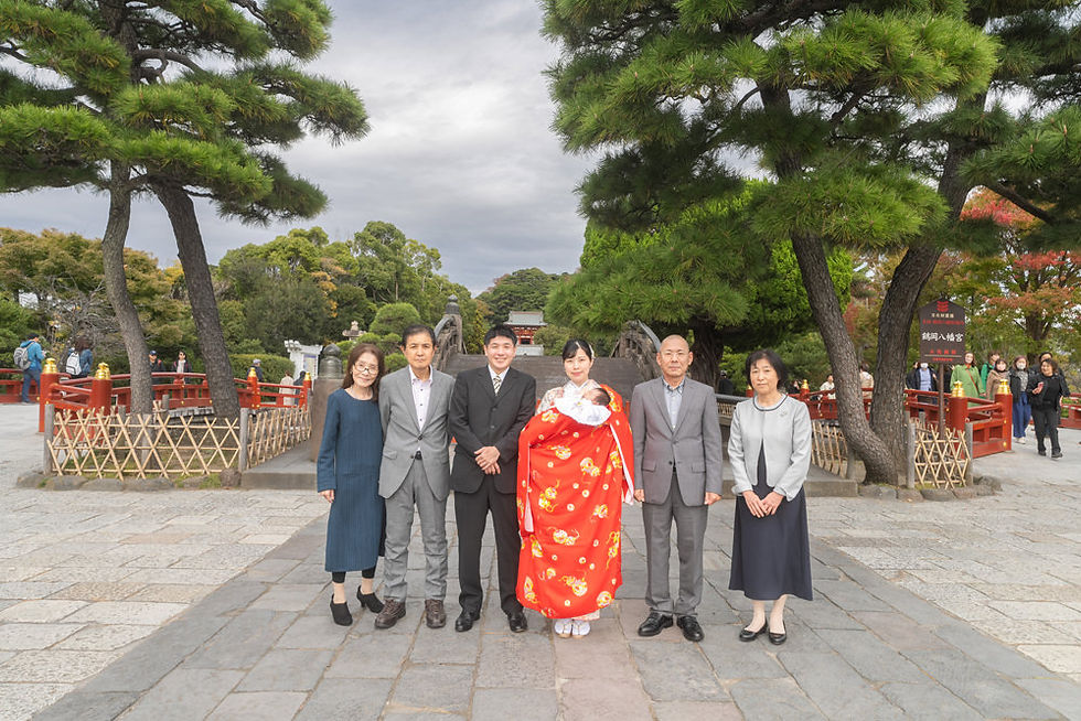 鶴岡八幡宮のお宮参りで、段葛奥の太鼓橋を背景にご家族揃って撮影した記念写真。祖父母も参加した鎌倉でのお宮参り出張撮影の様子。