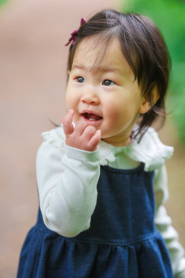 井の頭公園で笑顔を見せる1歳の女の子のクローズアップ写真
