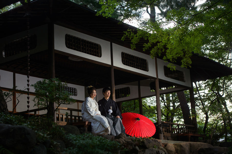 殿ヶ谷戸庭園の縁側に並んで座る新郎新婦、白無垢と黒紋付袴が映える和装フォト