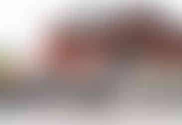 Couple sharing a kiss beneath red torii gates at Hanazono Shrine during their Japan-inspired engagement shoot