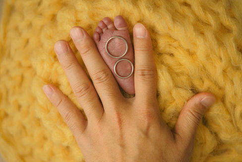 パパとママの結婚指輪を赤ちゃんの足に乗せて