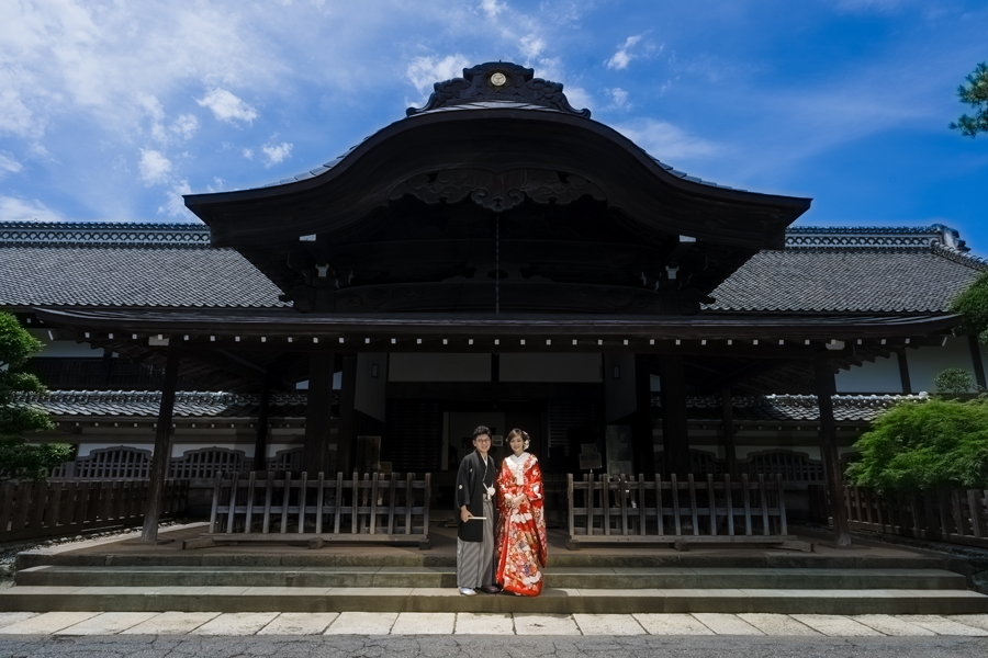 川越城本丸御殿の正門前で、新郎新婦が並んで立つ和装前撮り写真