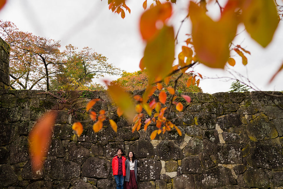 Autumn couple portrait beside the historic stone walls of Tsuruga Castle in Aizu