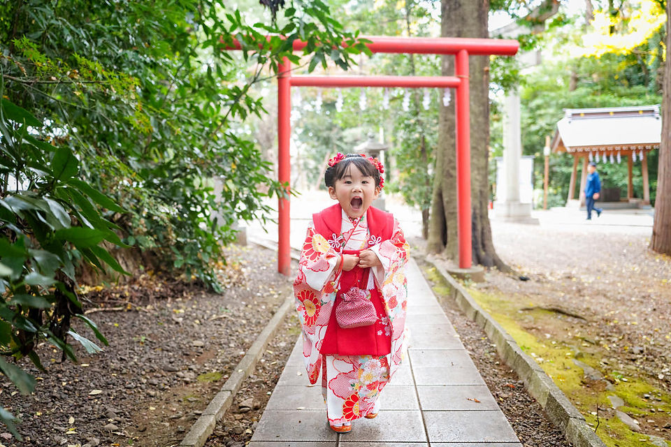 谷保天満宮の境内で笑顔を見せる七五三の3歳の女の子