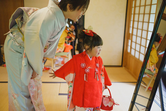 田母沢御用邸の和室で七五三の着物姿を鏡で確認する女の子と母親