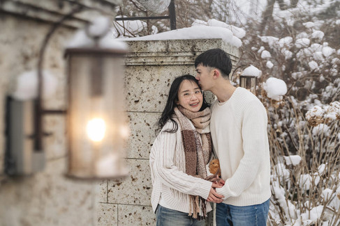 Romantic couple portrait with soft kiss on forehead in snowy garden Kawaguchiko Japan winter