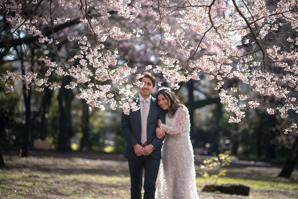 Couple walking beneath cherry blossoms in Tokyo during a spring elopement photography session in Japan