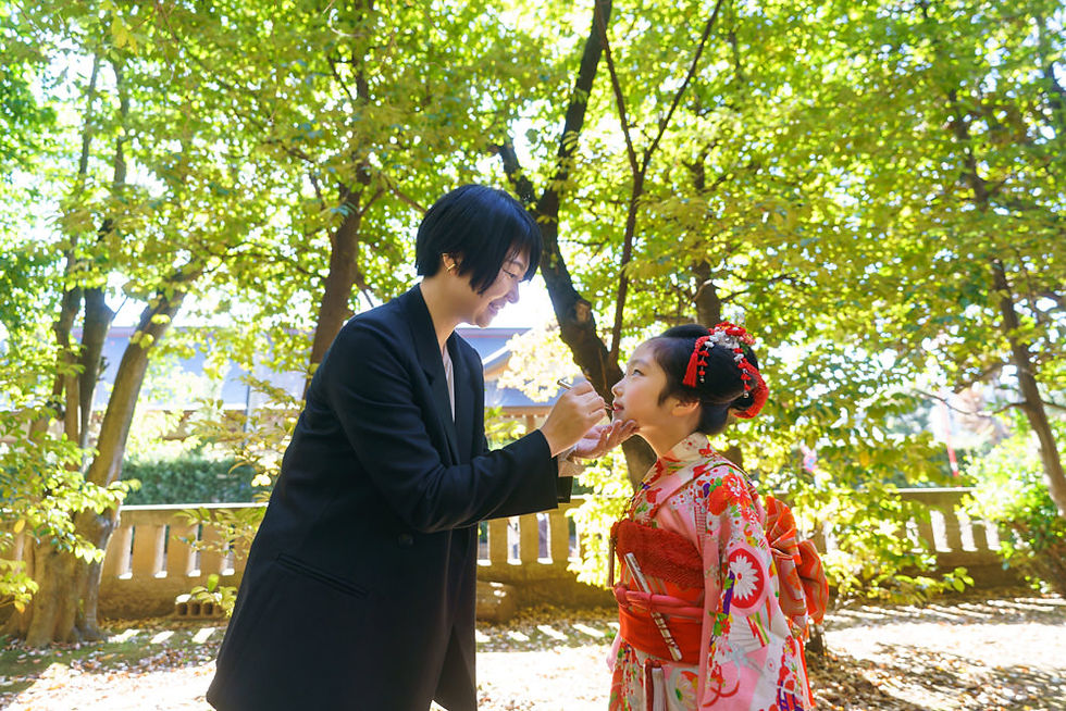 世田谷八幡宮の境内で、母親が娘の口元を直す七五三らしい自然な親子の写真