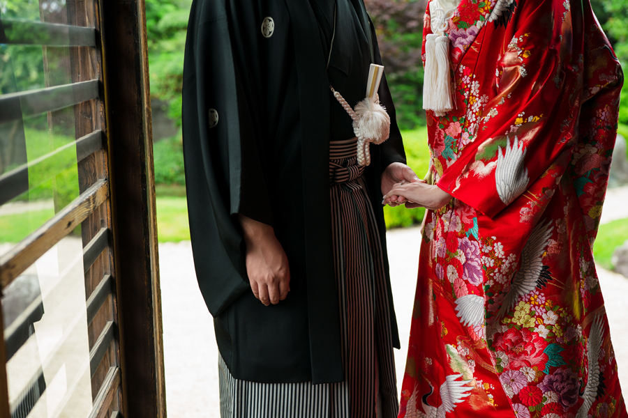 和室の縁側で手を取り合う新郎新婦の手元を写したクローズアップ