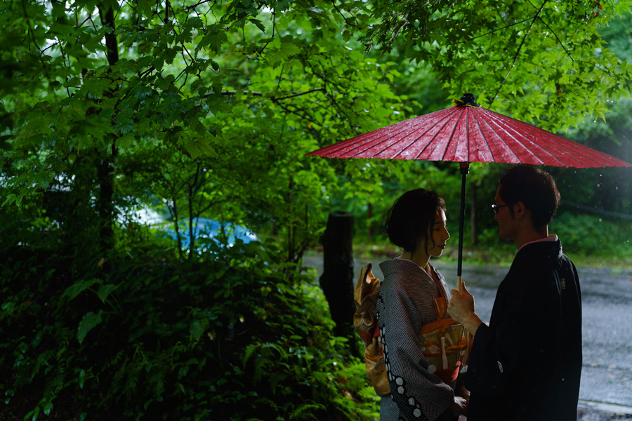 赤い和傘をさし、雨の中で寄り添う軽井沢の和装前撮りカップル