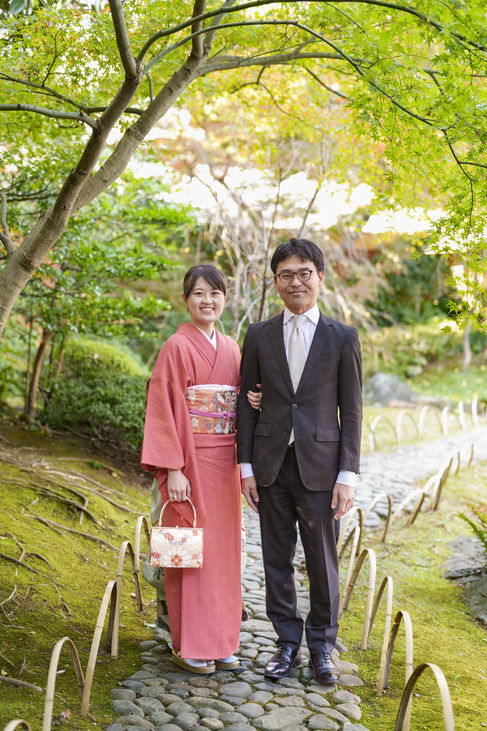 靖国神社の日本庭園で七五三撮影をする両親 着物とスーツでの記念写真