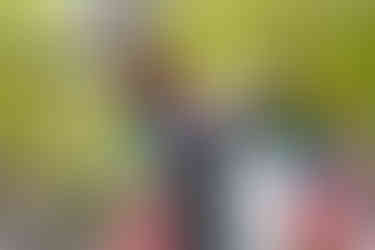 赤い橋と新緑を背景に、振り返る和装の新郎新婦を写した井の頭公園での前撮り写真。