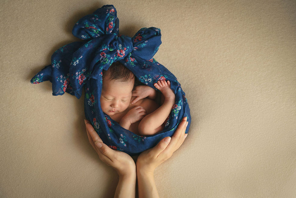 青い布に包まれた赤ちゃんを両手で支えるニューボーンフォト｜おくるみに包まれた安心感ある新生児写真