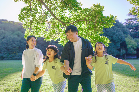 Family holding hands while walking through Kinuta Park during a morning photography session