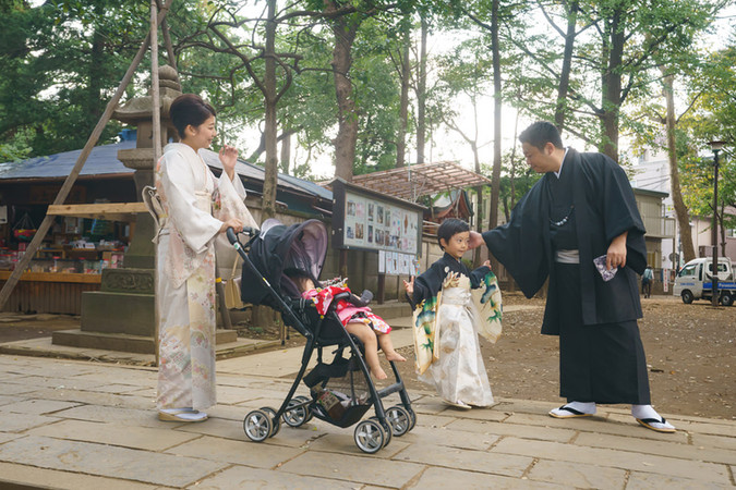 鬼子母神の境内を歩く七五三のご家族。5歳男の子と妹、両親の自然なやりとりを残した記念写真