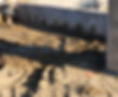 On a construction sight, a piece of rebar is protruding vertically from the ground, whose exposed end is capped off with a red cap to prevent anyone from walking or falling onto it and being impaled.
