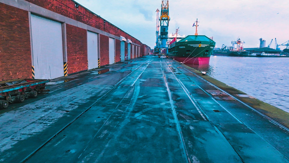 A ship moored by the dock next to a warehouse building in the port of Hull.