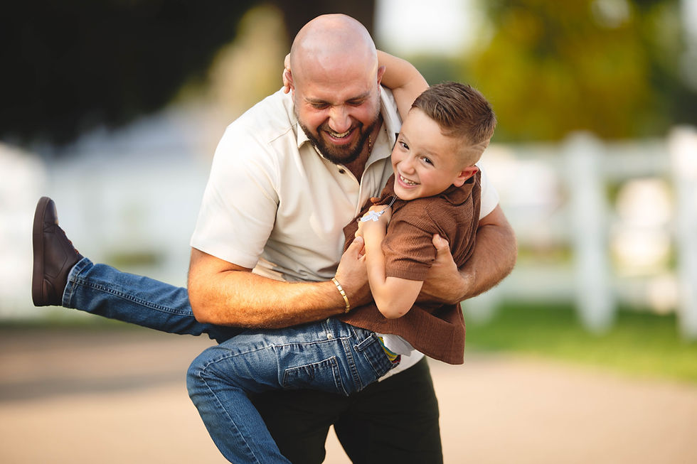 Father and son sharing a candid moment during family portraits