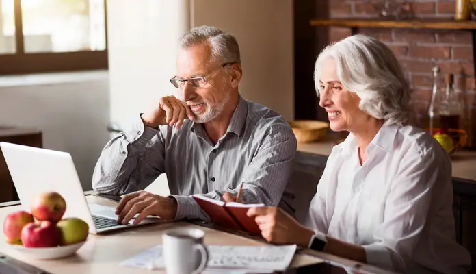 happy-couple-looking-at-laptop.webp