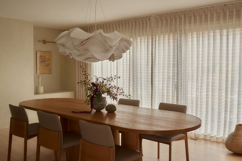 Dining area featuring leather chairs, a wooden table, and natural light highlighting soft cream and natural accents.