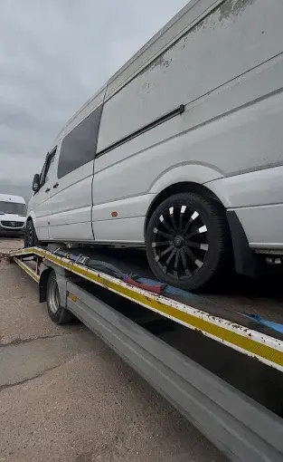 White van loaded onto a flatbed tow truck