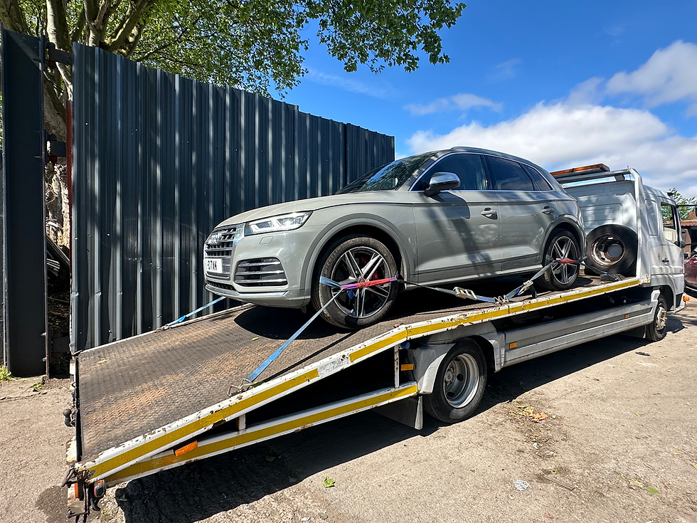 Grey Audi SUV on a flatbed tow truck